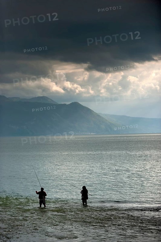 Angler in rainy weather against the light, weather, clouds, cloudy, fishing, hobby, fishing on the promenade in Vevey on Lake Geneva, Vaud, Switzerland, Europe