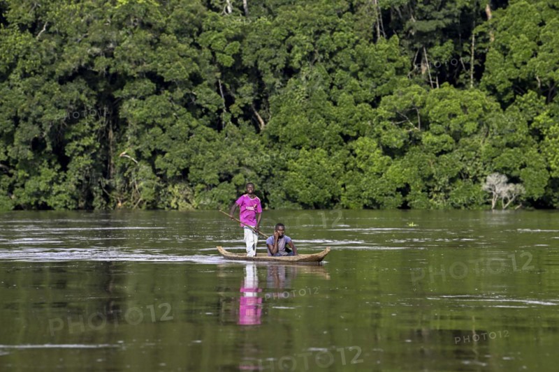 Two young men in a dugout canoe on the Sangha River, Dzanga-Sangha Complex of Protected Areas (DSPAC), Sangha-Mbaéré Prefecture, Central African Republic, Africa