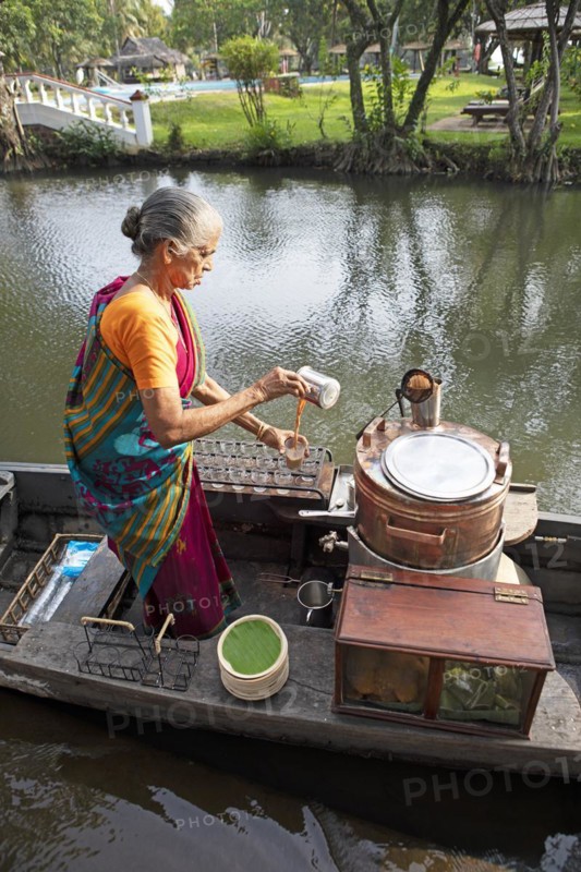 Tealady, 83 years old, making Indian tea on her boat, Backwaters, Kumarakom, Kerala, India, Asia
