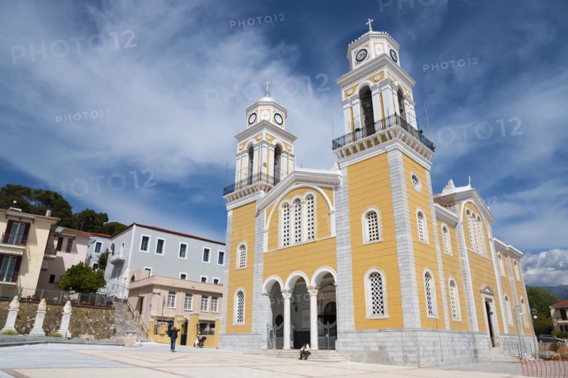 A yellow church with two clock towers under a blue sky, in front of a paved square, Cathedral, Ypapantis Sotiros, Kalamata, Messinia, Peloponnese, Greece, Europe