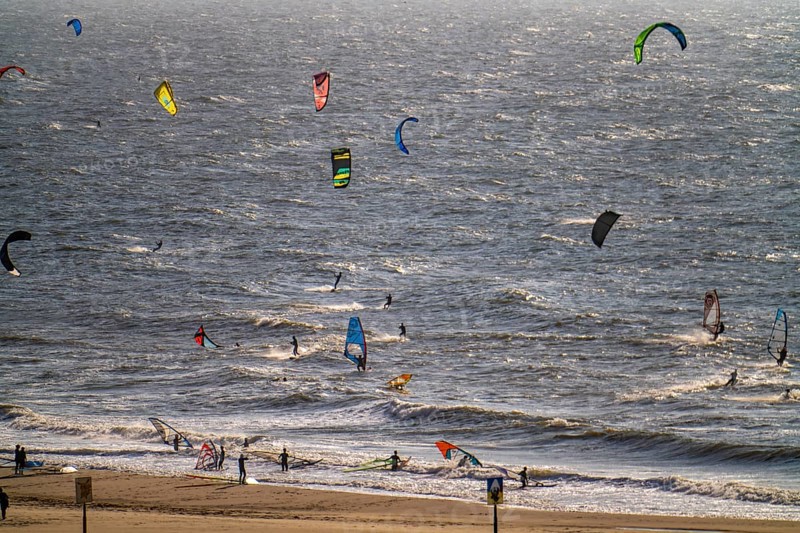 Kitesurfers and windsurfers in strong winds on the beach of Scheveningen, The Hague, Netherlands