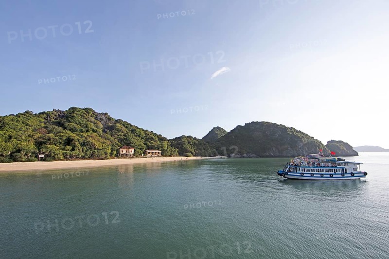 Excursion boat anchored on the beach of Monkey Island, behind the karst rocks in Lan Ha Bay, Halong Bay, Vietnam, Asia