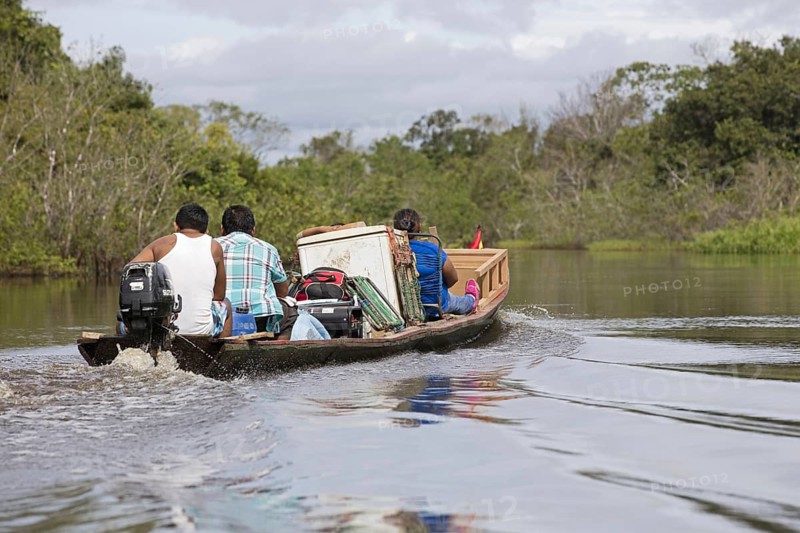Local Bolivians moving furniture by canoe with outboard motor on the Yacuma River in the Pampas del Yacuma in Bolivia