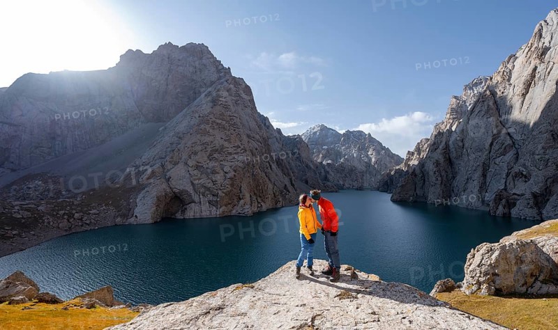 Couple kissing at the blue mountain lake between rocky steep mountain peaks, Kol Suu Lake, Sary Beles Mountains, Naryn Province, Kyrgyzstan, Asia