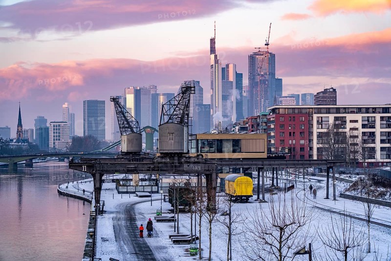The skyline of Frankfurt am Main, skyscrapers of the banking district, historic harbour cranes at the Wesel shipyard, wintry morning, Hesse, Germany, Europe