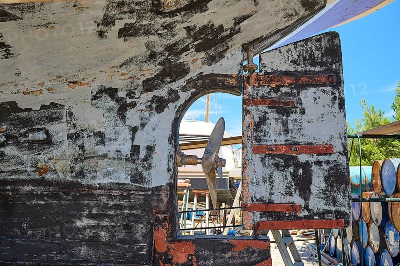 Weathered hull with propeller and defective stern rudder, Patmos Marine, boatyard, Diakofti, Patmos, Dodecanese, Greek Islands, Greece, Europe