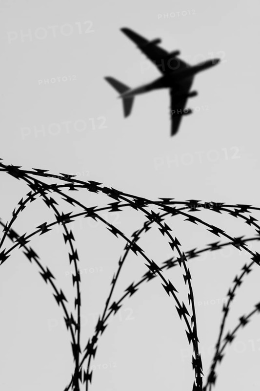 Symbolic image, deportation flights of illegal and delinquent migrants, passenger aircraft, airport, security fence, barbed wire, black and white image, Germany, Europe