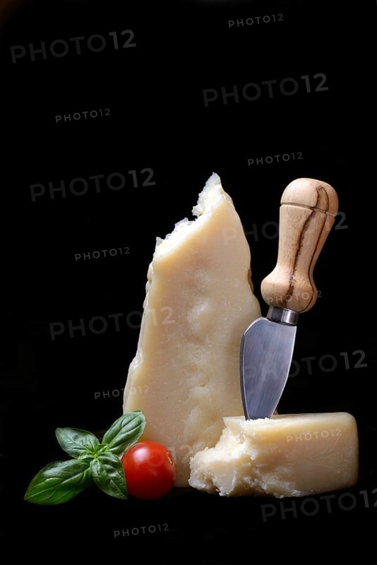 A piece of Parmesan cheese with cheese knife, basil and tomato, Italy, Europe