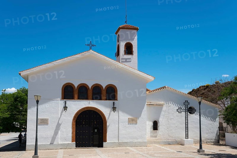 White church with bell tower under a clear blue sky with symbolic religious details, Nuestra Señora de Gracia, Church of Our Lady of Grace, cave neighbourhood, Troglodytos, Barrio de Cuevas, Guadix, Granada province, Andalusia, Spain, Europe
