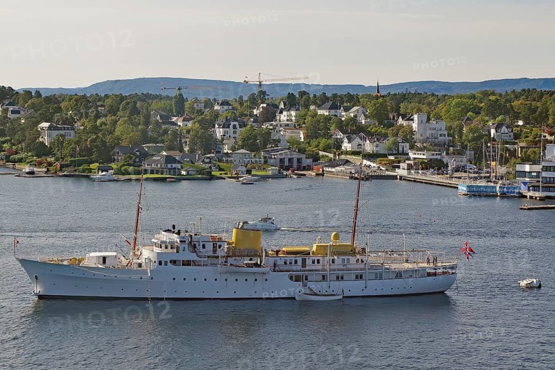 Large ship on the water in front of a coastal town with white houses and green hills, the yacht of the royal family, museum peninsula, capital, Oslo, Norway, Europe