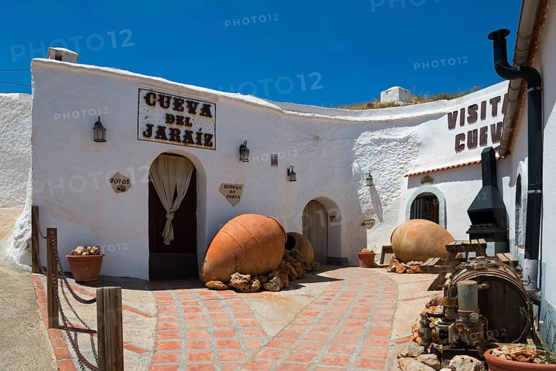Rustic cave house with white walls and traditional decorations under a sunny sky, Cueva del Jaraiz, cave dwelling, cave neighbourhood, Troglodytos, Barrio de Cuevas, Guadix, Granada province, Andalusia, Spain, Europe