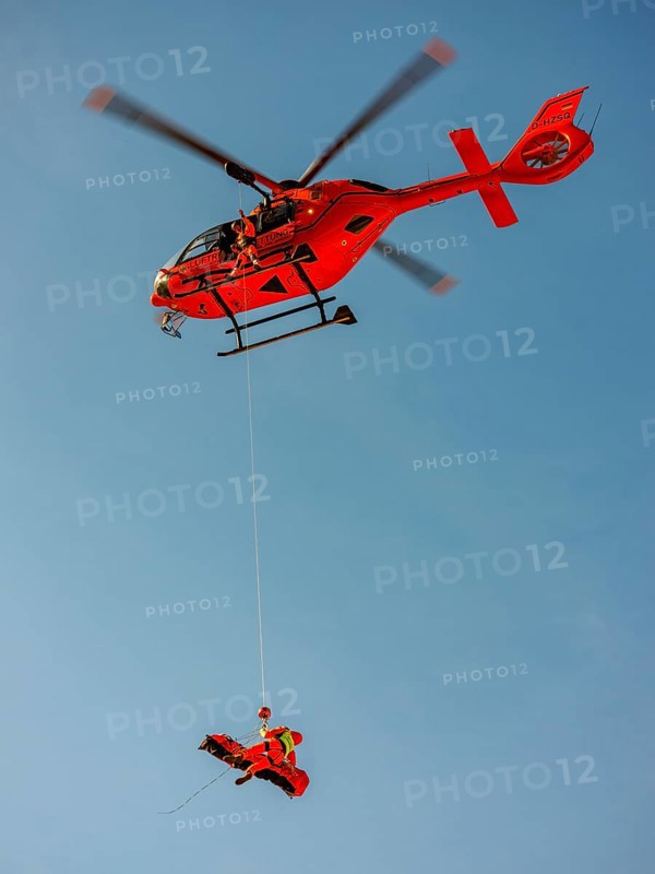 Injured person in a mountain bag with an air rescuer being winched into the rescue helicopter Christoph 14 with the cable winch, Bad Reichenhall, Berchtesgadener Land, Upper Bavaria, Bavaria, Germany, Europe
