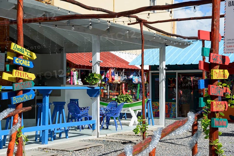 A Caribbean market with colourful signs and souvenirs under an outdoor wooden structure, Bayahibe, Dominican Republic, Hispaniola, Caribbean, America, Central America