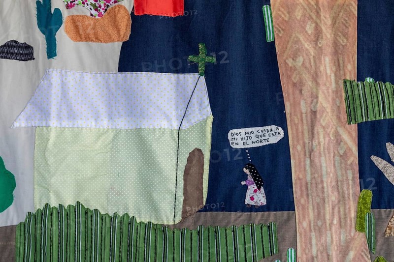 Tanivet, Oaxaca, Mexico, Virtually all the men in this small village have left for the United States to find work. The women who remain have formed an artist coooperative, embroidering the story of their separation. They call themselves Las Hormigas Bordadoras de Tanivet (embroidering ants) . A section of a large embroidery shows a woman praying: God watch over my son who is in the North, Central America