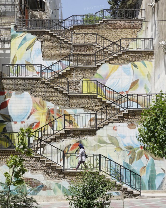 Passers-by walk up a staircase painted with roses in Tehran. The city of Tehran is changing the image of the city through art objects in public spaces, 17.05.2016