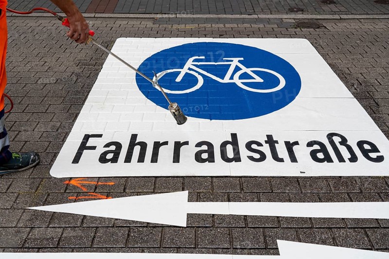 Application of road markings for a cycle lane, Rüttenscheider Straße in Essen, in the shopping and gastronomy district, cyclists have right of way over motorised vehicles, part of a cycle axis through Essen's city centre