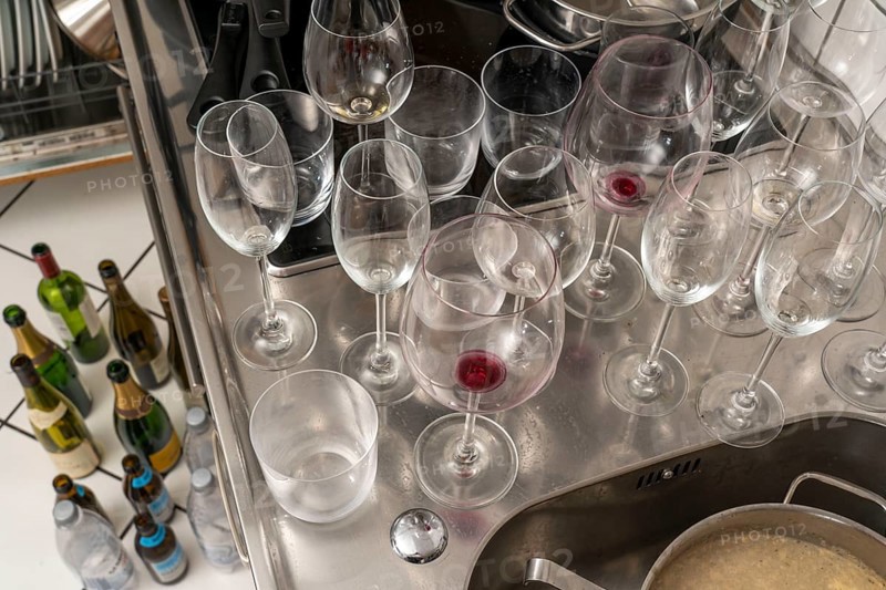 Kitchen after a big dinner, cooking party, dishes, dirty glasses, cooking utensils on the sink, waiting to be washed up