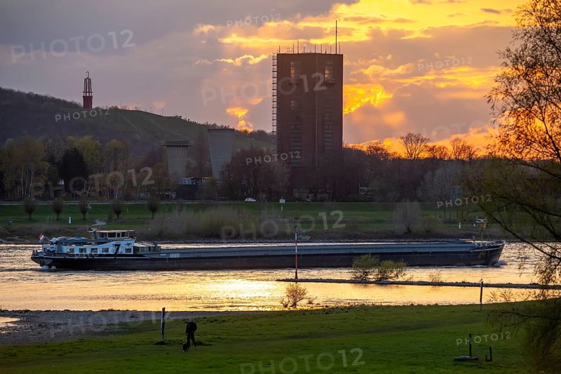 Cargo ship on the Rhine near Duisburg-Beeckerwerth, Rheinpreussen spoil tip in Mörs, spoil tip sign Das Geleucht, winding tower of the former Rheinpreußen Schacht VIII colliery, Duisburg, North Rhine-Westphalia, Germany, Europe