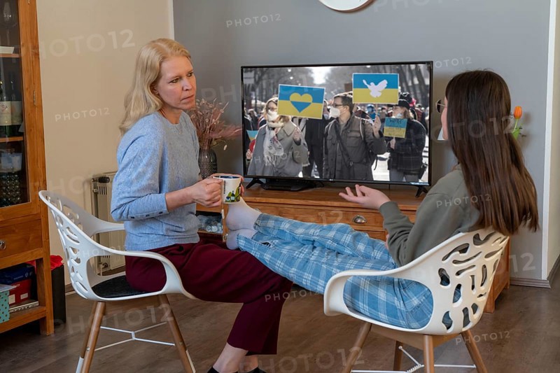 Mother and daughter, teenage, 13 years old, in a confidential conversation, at home, talking about fears, in connection with war, flight