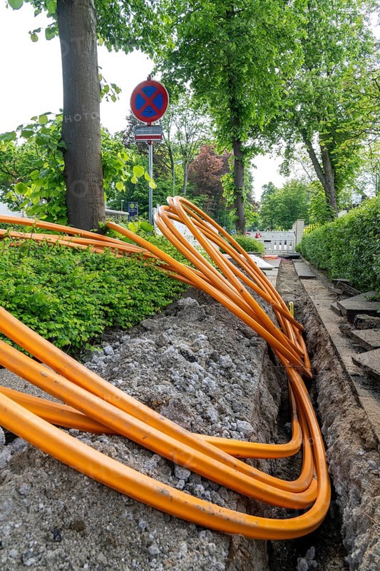 Laying of fibre optic cables, empty conduits are laid under a pavement, in which the actual fibre optic cable is later blown in and connected to the respective house connection or distributor. Essen, North Rhine-Westphalia, Germany, Europe