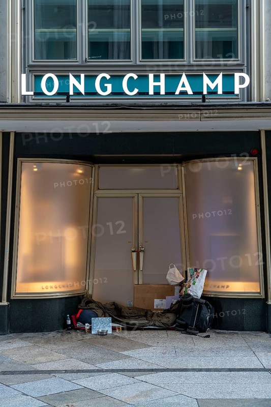 Camp of a homeless person, in the entrance of a Longchamp leather goods shop, at the Domplatte, in Cologne, during the Christmas lockdown in December 2020, North Rhine-Westphalia, Germany, Europe