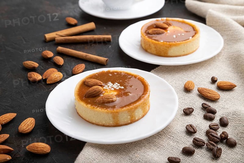 Sweet tartlets with almonds and caramel cream with cup of coffee on a black concrete background and linen textile. Side view, close up