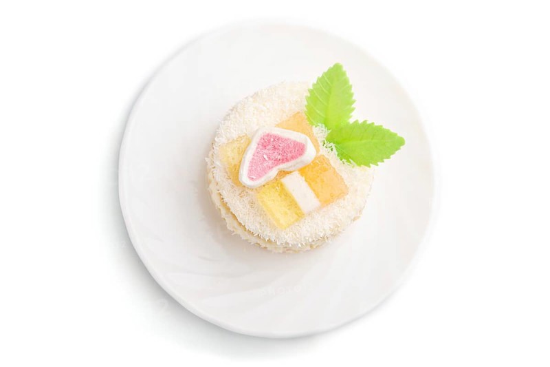 Decorated cake with milk and coconut cream isolated on white background. Side view, close up