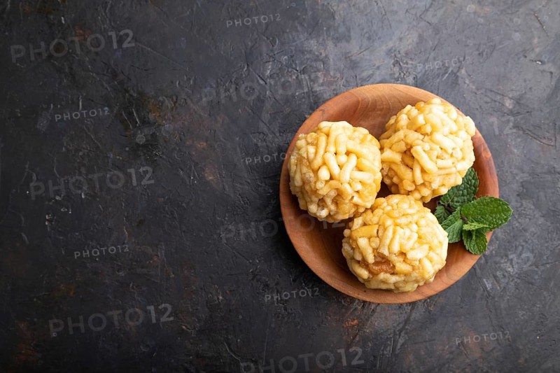 Traditional Tatar candy chak-chak made of dough and honey in wooden plate on a black concrete background. top view, flat lay, copy space