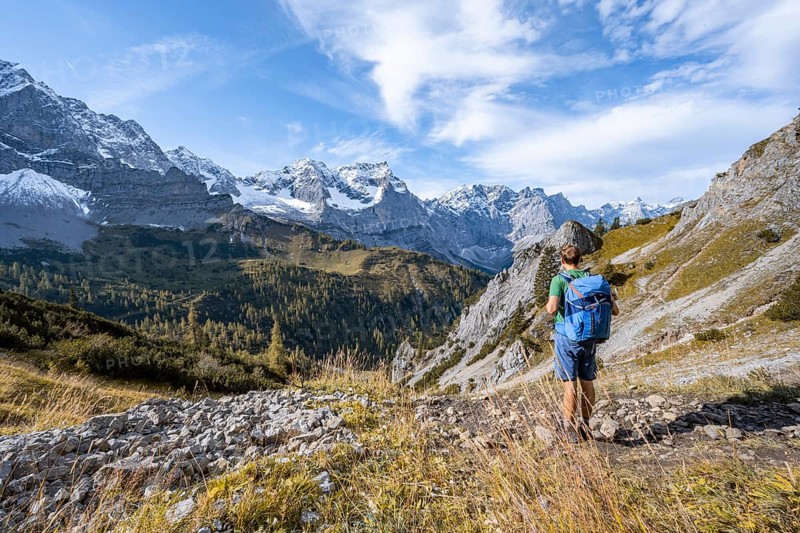 Mountaineers on a hiking trail, mountain panorama with rocky steep peaks, yellow-coloured larches in autumn, view of summits Laliderspitze, Dreizinkenspitze and Spritzkarspitze, hike to the summit of Hahnkampl, Engtal, Karwendel, Tyrol, Austria, Europe