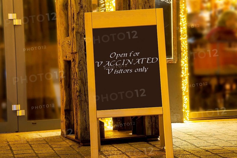 Street sign in front of a restaurant with the inscription Open for Vaccinated Visitors only (symbolic image, Composing)