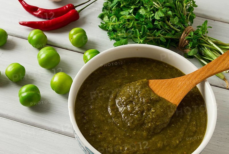 Tkemali sauce, traditional Georgian cuisine, green cherry plum, with ingredients for sauce, cilantro, mint, hot pepper, garlic, on a white wooden table, close-up, rustic, food background, no people, selective focus, sauce, green sauce, tkemali, georgian cuisine, homemade