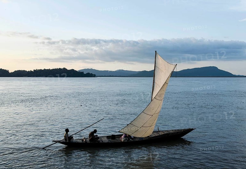 Fishermen paddle down the Brahmaputra River after fish in Guwahati, Assam, India on August 25, 2019