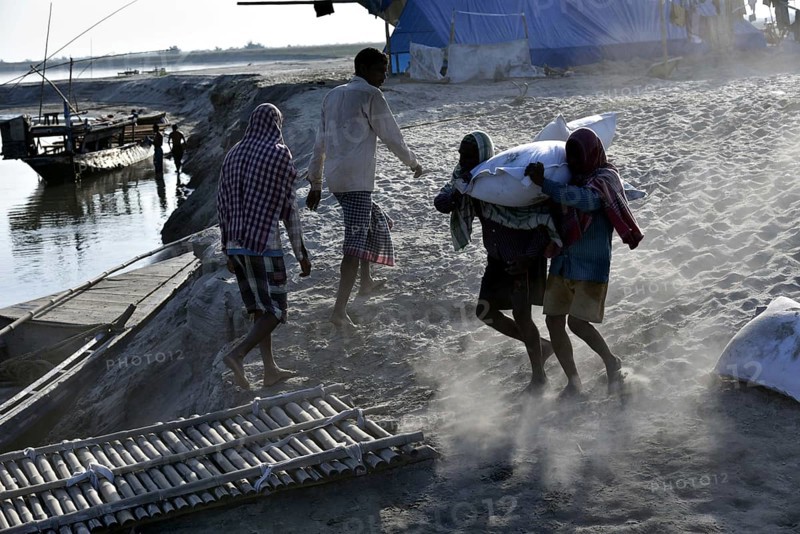 Public Works Department (PWD) of Assam labourer carrying sand bag to boat in Beki River to make sand bag wall to reduce soil erosion in Barpeta, Assam in India on Tuesday, November 13, 2018. The soil erosion of Beki river has become a major problem of flowing two districts Barpeta and Baksa of Assam