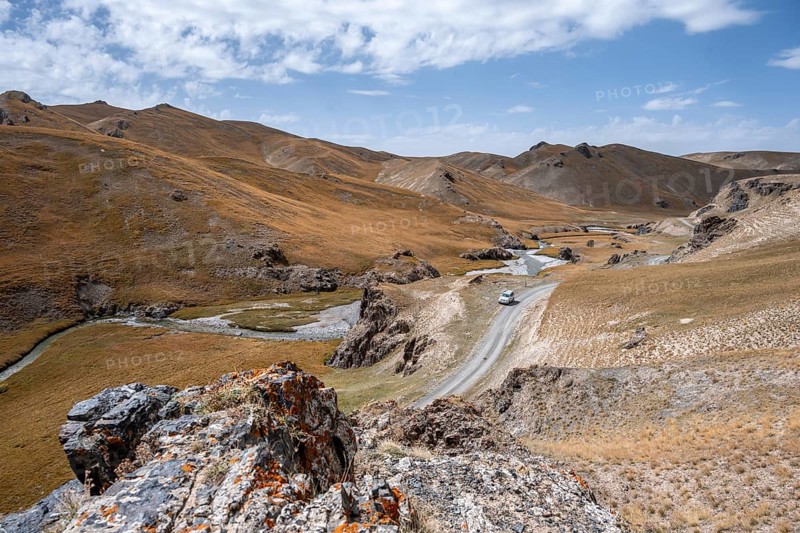 Off-road vehicle on a road, track between hills with yellow grass, Kol Suu river winds through a mountain valley, Naryn province, Kyrgyzstan, Asia