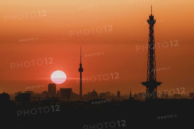 The sunrise emerges behind the city skyline with the television tower and the radio tower in Berlin, 04/09/2024