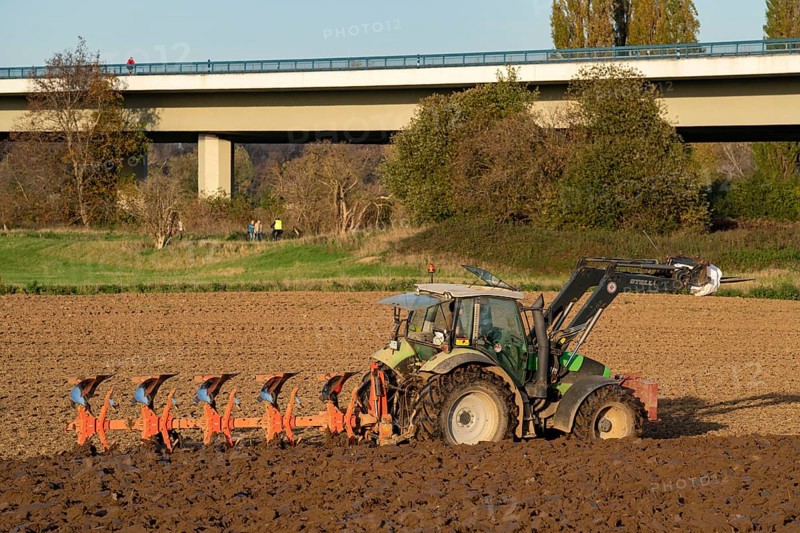 Farmer ploughing a field, tractor with plough, near Neuss, Fleher motorway bridge, A46, North Rhine-Westphalia, Germany, Europe