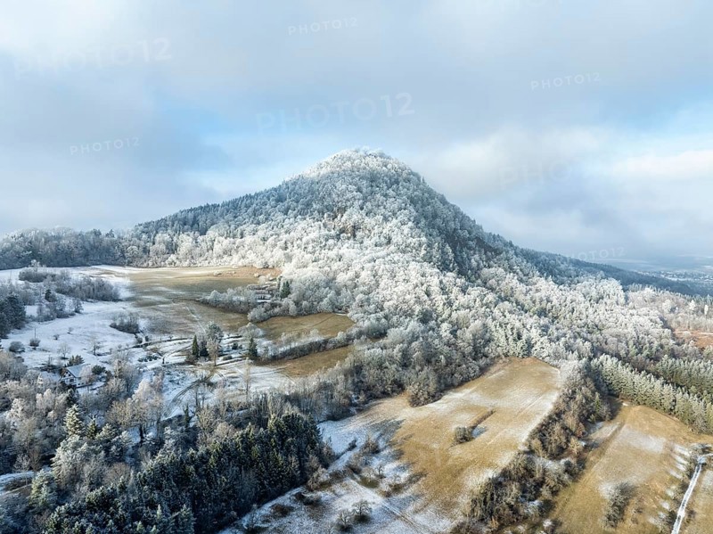 Aerial view of the snow-covered Hegau volcano Hohenhewen, surrounded by frosty trees in a winter landscape, Engen, district of Constance, Baden-Württemberg, Germany, Europe