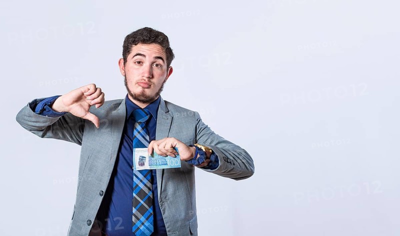 Business man holding banknote with thumb disapproving, man with money in hand and thumb down