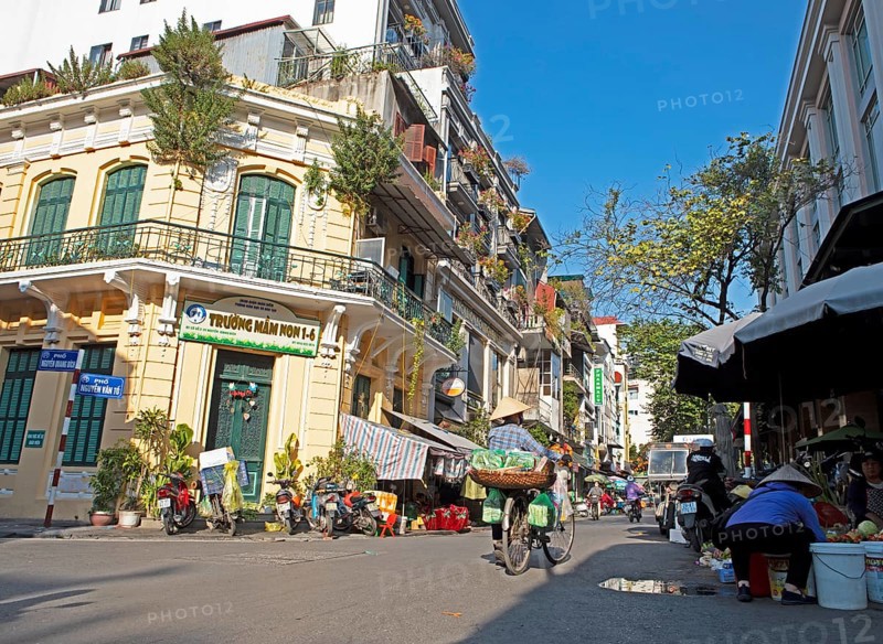 Vietnamese saleswoman with conical hat pushing her bicycle through the Old Quarter, Hanoi, Vietnam, Asia
