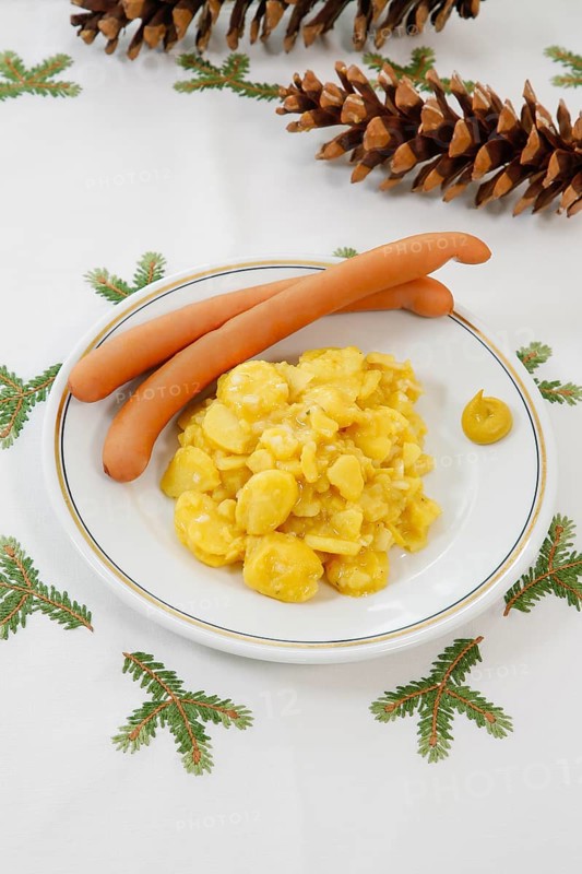 Swabian cuisine, potato salad with string sausages, Wienerle, Wiener sausages, thin boiled sausage, horseradish sausage, Frankfurter sausage, savoury, salty, typical Swabian, typical Christmas dinner, fast food for Christmas Eve, home cooking, plate, mustard, Christmas decoration, hand-embroidered table linen, Christmas motifs, fir branch motif, Christmas tablecloth, fir cones, handicraft, traditional cuisine, food photography, studio, Germany, Europe