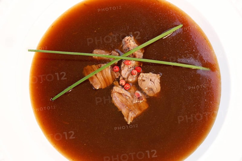 Southern German cuisine, oxtail soup with red pepper in a soup plate, bound soup, meat soup, chives, soup plate, traditional cuisine, speciality, food photography, studio, Germany, Europe