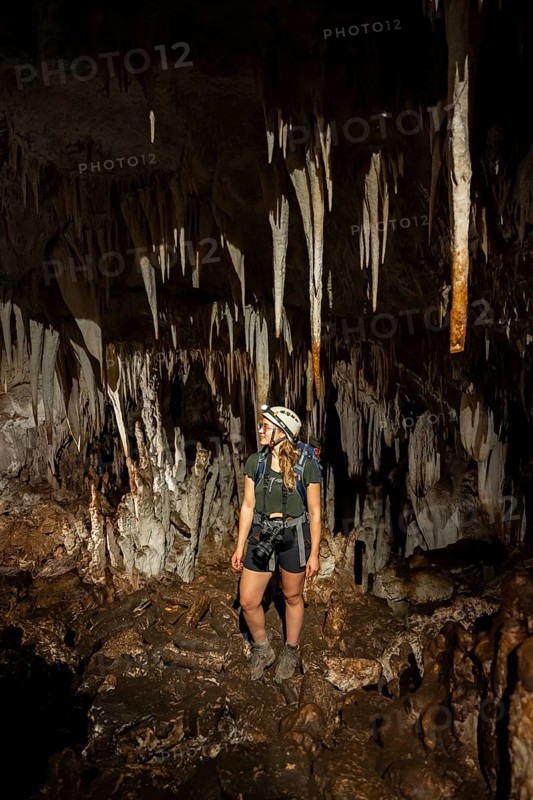 Young woman with helmet and headlamp, tourist between stalactites and stalagmites in a stalactite cave, Terciopelo Cave, Barra Honda National Park, Costa Rica, Central America