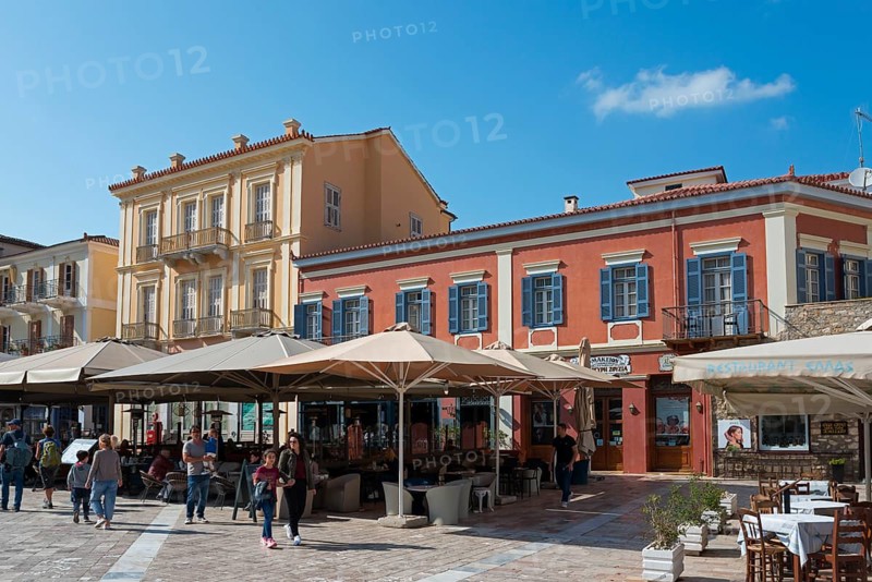 Historic city buildings with colourful facades and people strolling through a sunny city centre, Syntagma Square, Nafplio, Nauplia, Nauplion