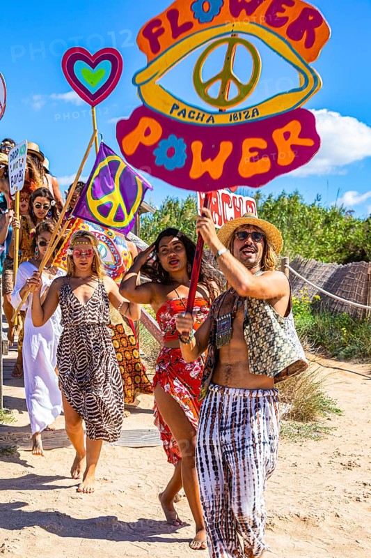 Colourfully dressed youths with musical instruments and banners form a love parade and promote the nightclub Pacha, Cala Comte, Ibiza, Balearic Islands, Mediterranean Sea, Spain, Europe