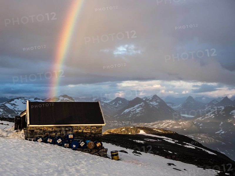 Mountain hut on top of mountain Fannaråken, storage hut, rainbow over Jotunheimen peaks, Jotunheimen National Park, Norway, Europe