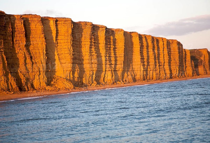 Golden afternoon light on sandstone cliffs, East Cliffs, West Bay, Bridport, Dorset, England, UK