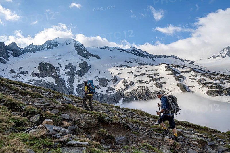 Two mountaineers on a hiking trail, high fog in the valley, glaciated mountains with Furtschagelkees, summit Großer Möseler, Berliner Höhenweg, Zillertal Alps, Tyrol, Austria, Europe