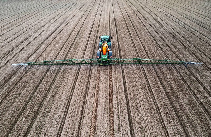 Farmer working a field, crop protection agent being sprayed, field with young sugar beet plants, North Rhine-Westphalia, Germany, Europe
