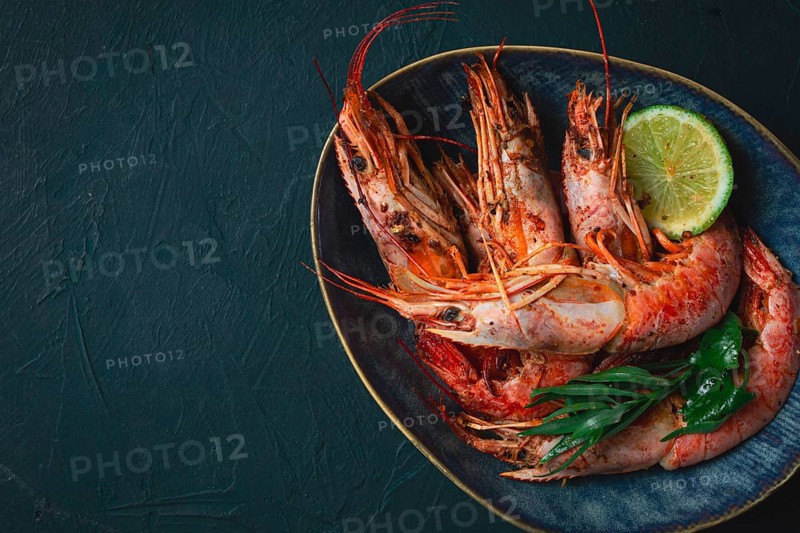 Langoustines, Australian, freshly frozen on ice, top view, lime and greens
