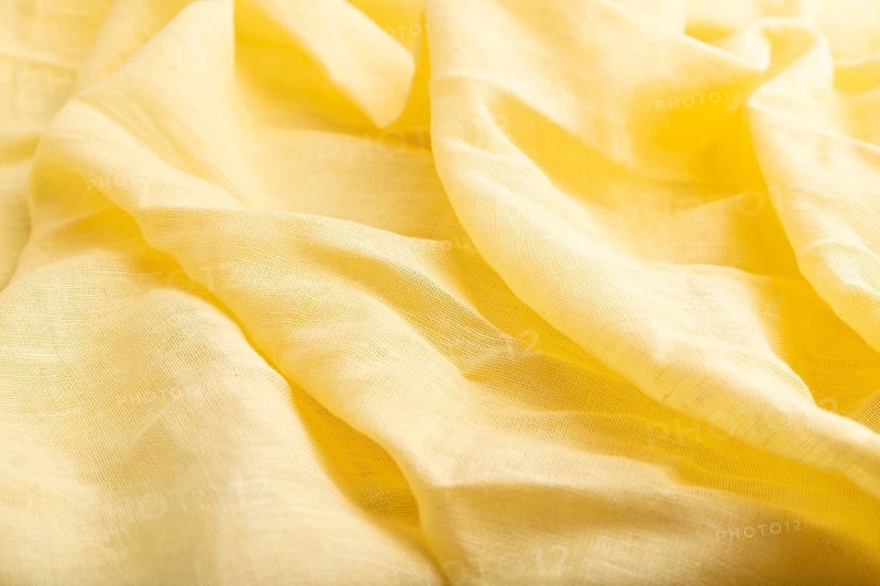 Fragment of yellow linen tissue. Side view, natural textile background and texture. wave concept, abstract